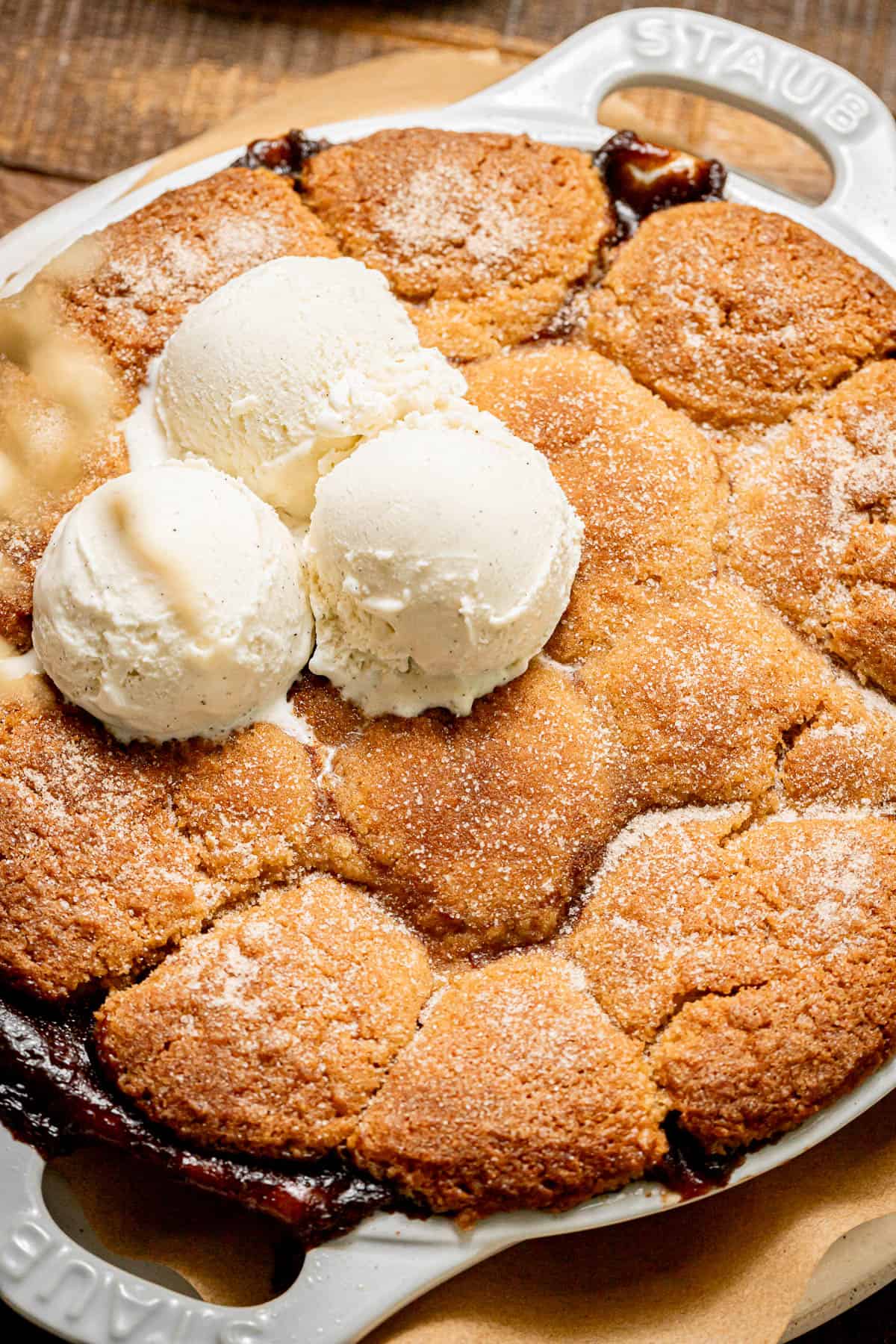 apple cobbler with ice cream scoops on top.