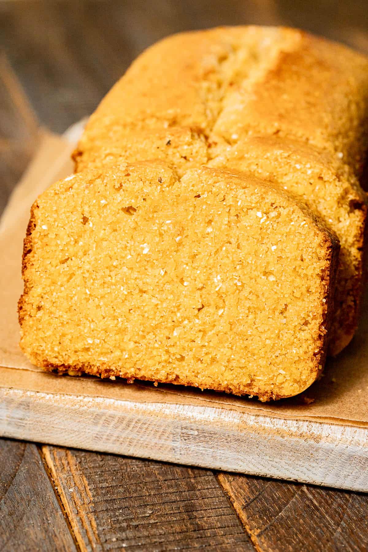 sweet honey cornbread cut into slices on cutting board. 