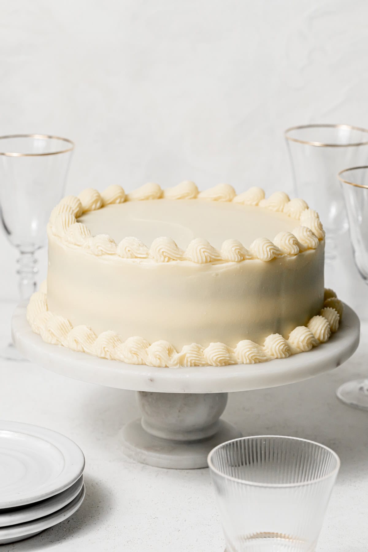 decorated red velvet layer cake on marble cake stand.