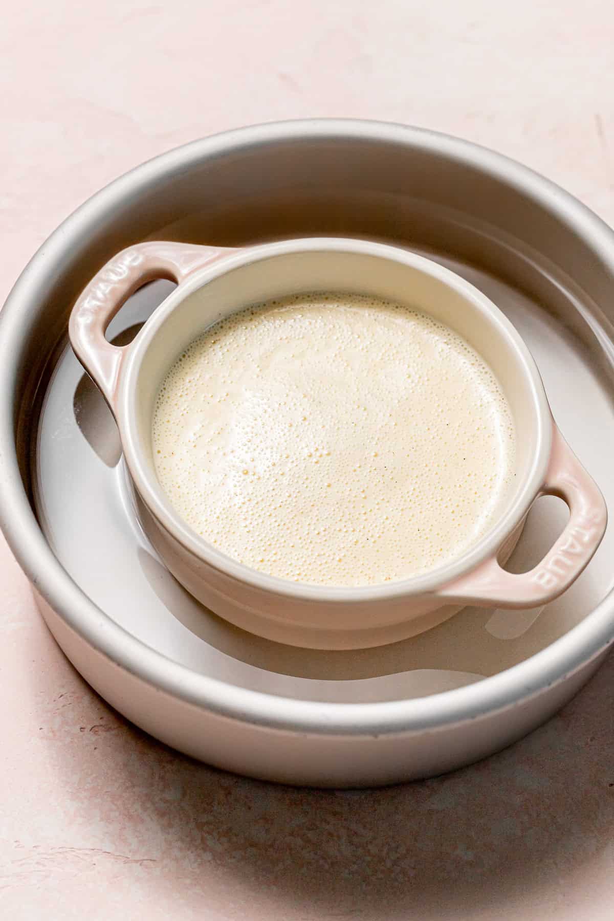 custard in mini cocotte in pan with water.