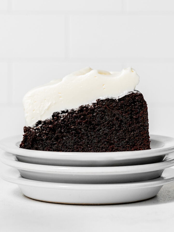 slice of chocolate Guinness cake on stack of white plates.