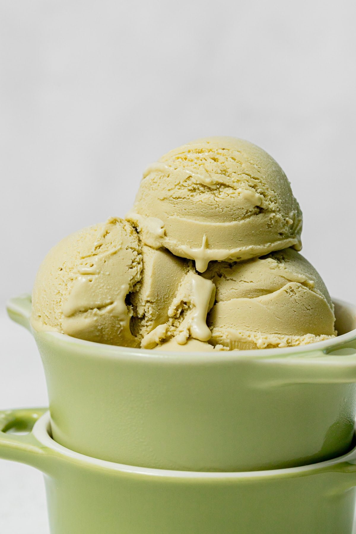 Sicilian Pistachio Ice Cream scoops in stacked green bowls.