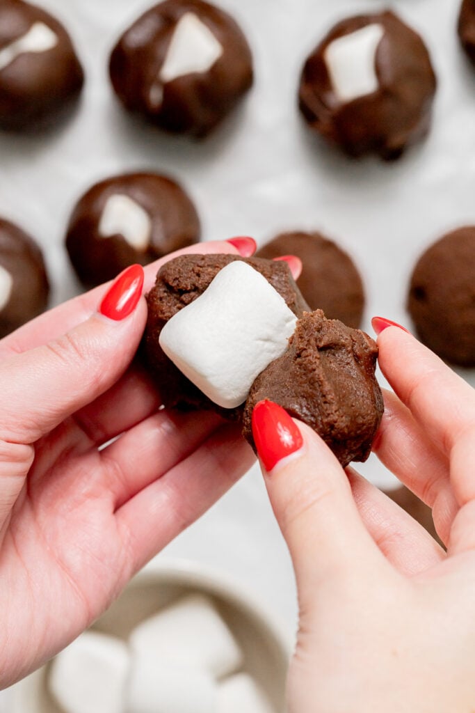 cookie dough ball being stuffed with a marshmallow.
