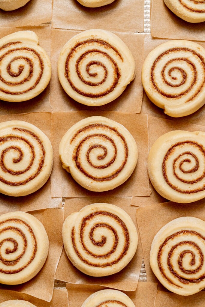 shaped cinnamon roll donut dough on baking sheet.