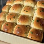 Garlic Herb Milk Bread Dinner Rolls lifted up out of pan.