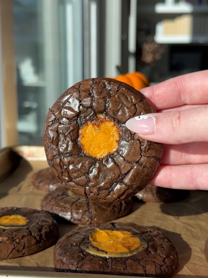 Pumpkin Cheesecake Brownie Cookie held in hand.