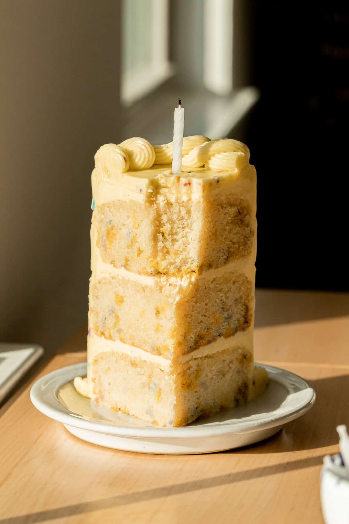 slice of funfetti cake standing up on plate.