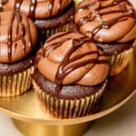 chocolate ganache cupcakes on gold cake stand.