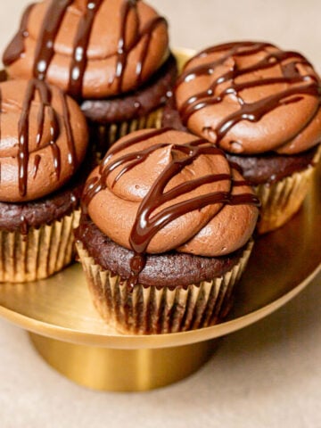 chocolate ganache cupcakes on gold cake stand.