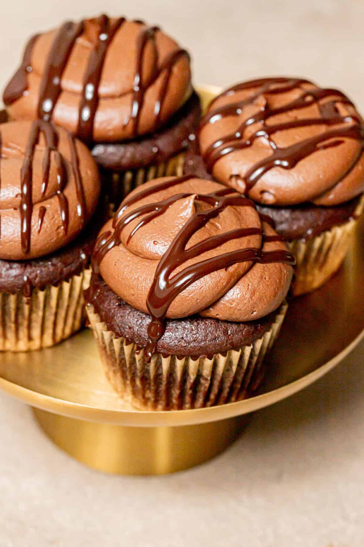 chocolate ganache cupcakes on gold cake stand.