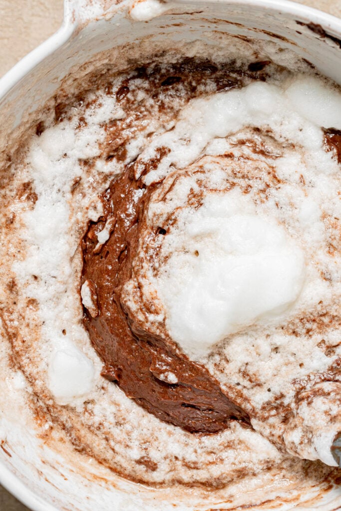 whipped egg whites being mixed into cake batter.