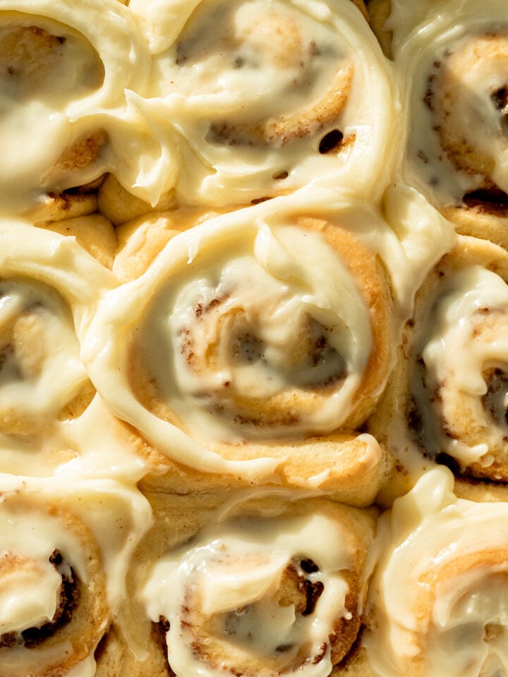 no knead cinnamon rolls with cream cheese frosting in pan.