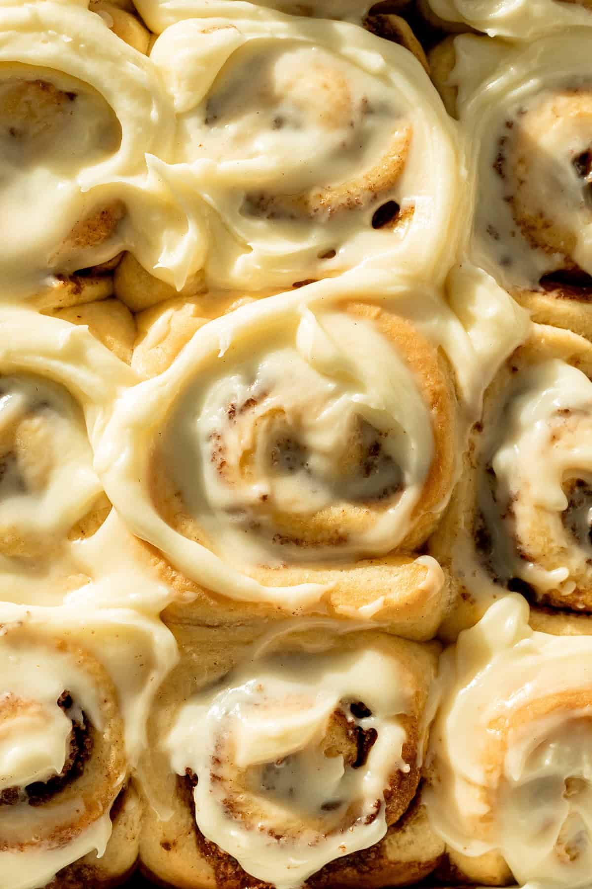 no knead cinnamon rolls with cream cheese frosting in pan.