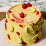 pistachio raspberry cake on marble platter.