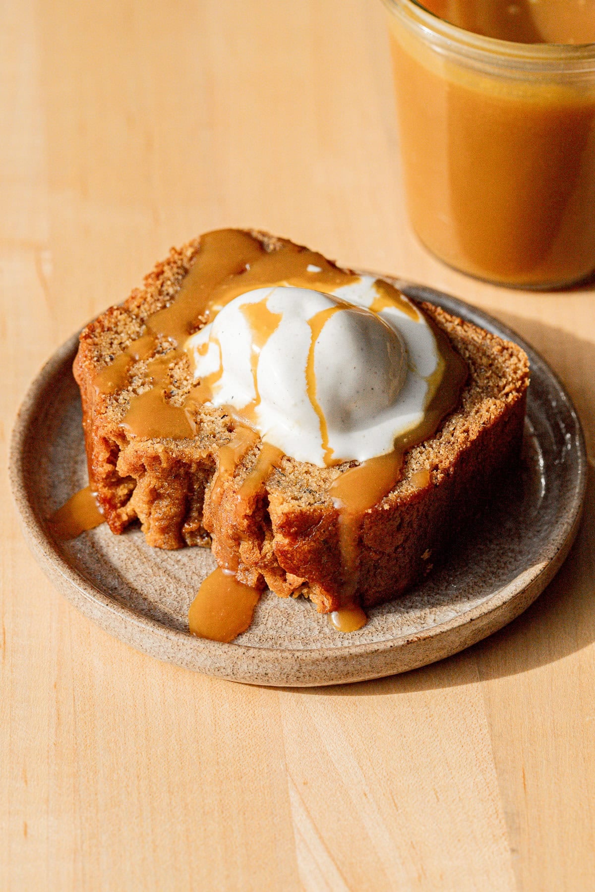 bourbon banana bread slice on plate with ice cream.