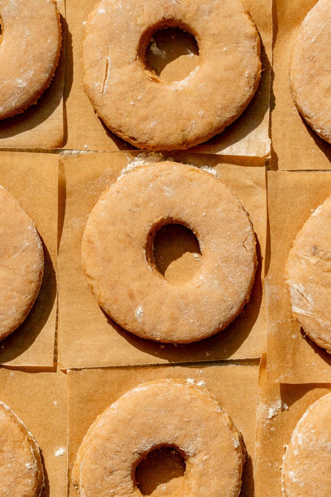 cutout donuts on parchment squares.