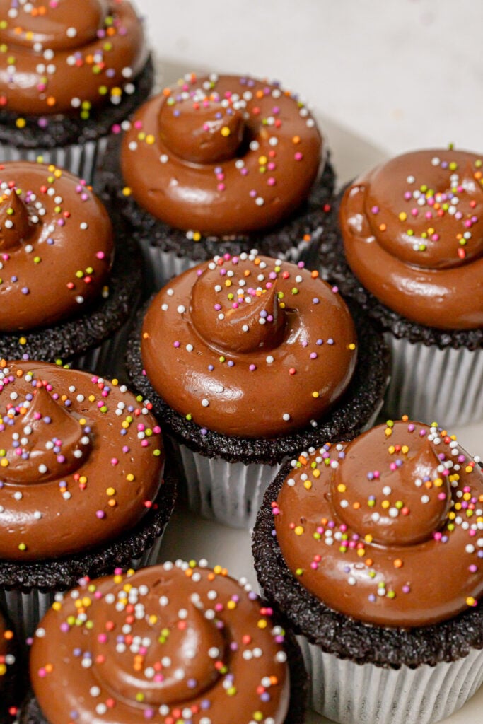 decorated chocolate cupcakes on marble round.