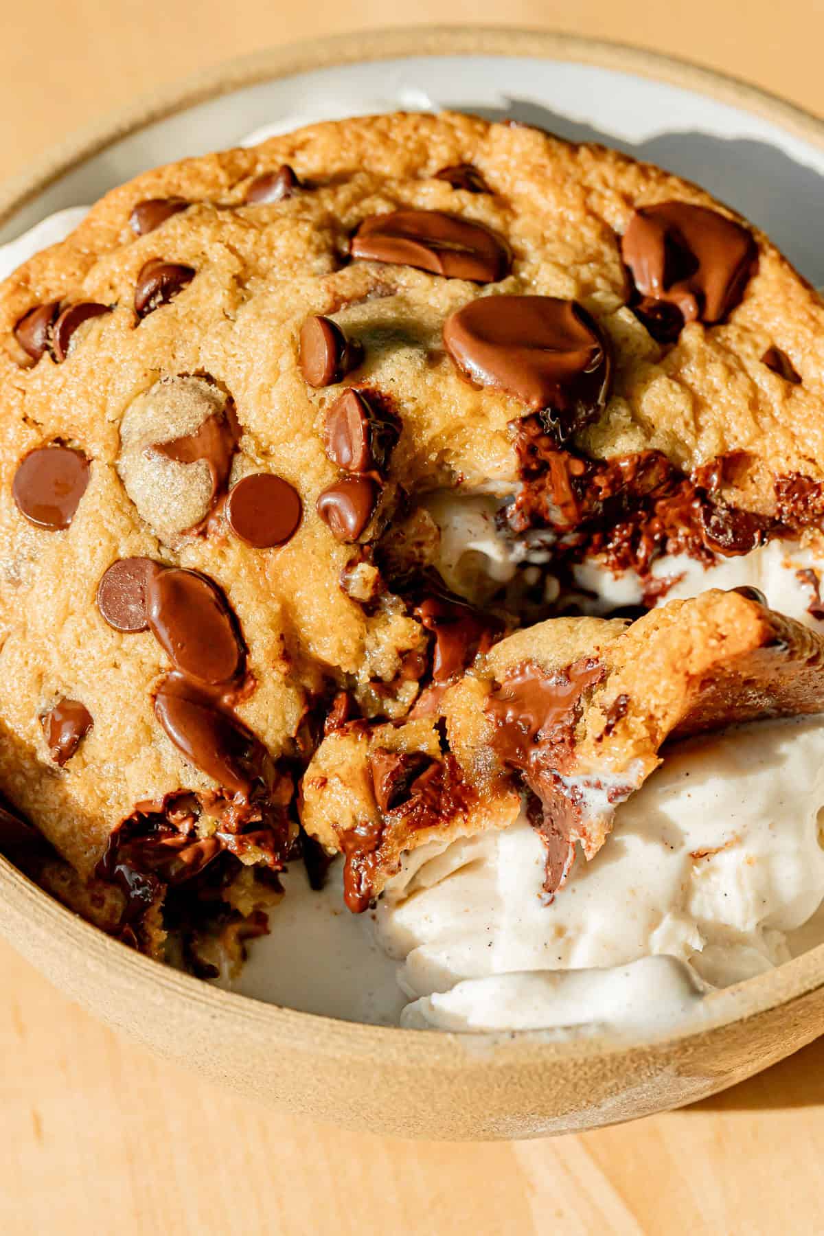 single serve chocolate chip cookie over ice cream in bowl.