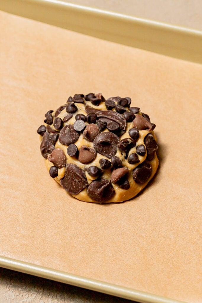 single serve chocolate chip cookie dough ball on baking sheet.
