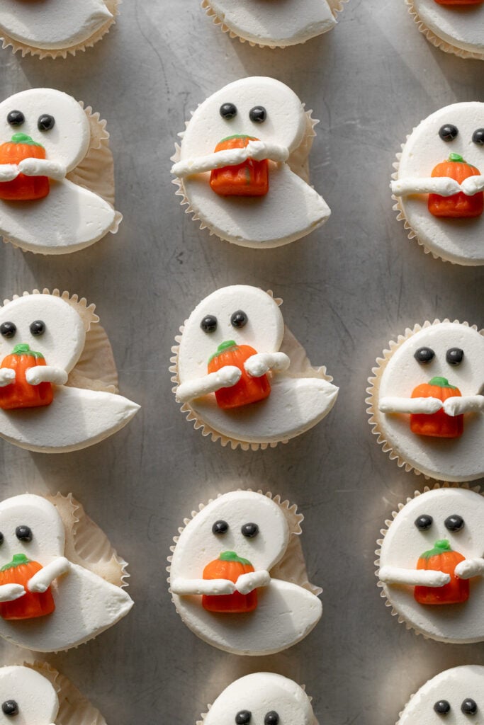 decorated White Ghost Cupcakes on baking sheet.