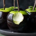 bite taken out of black poison caramel apple.