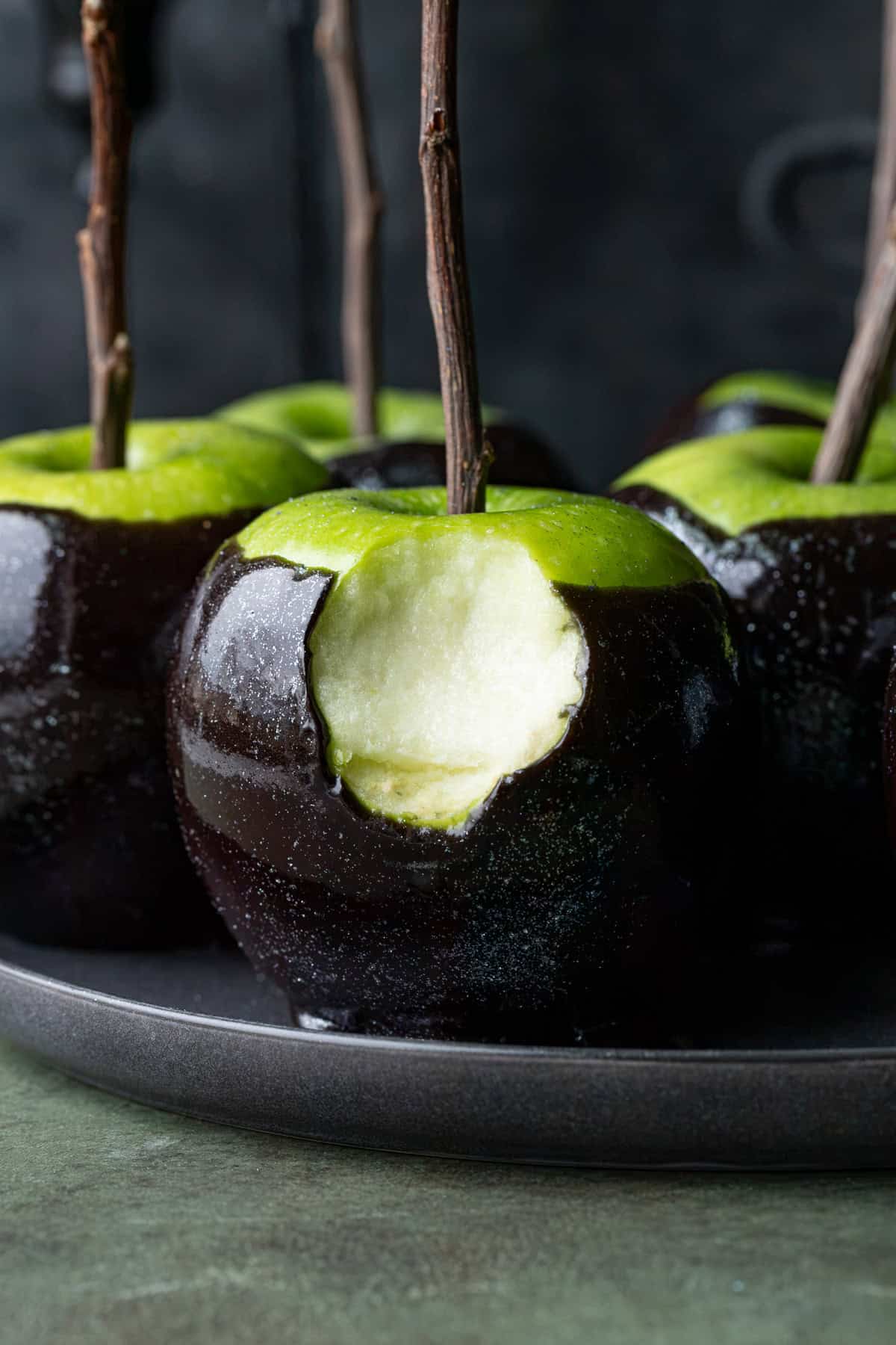 bite taken out of black poison caramel apple.