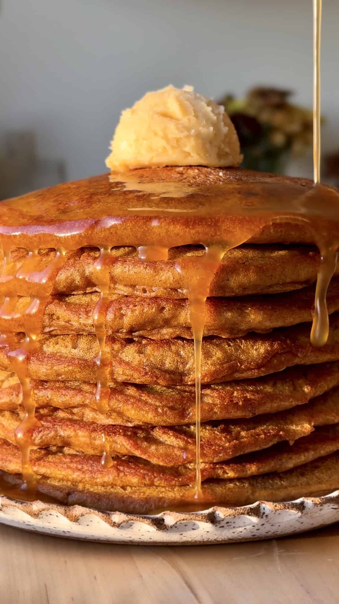 maple honey butter pumpkin pancakes stacked on plate.