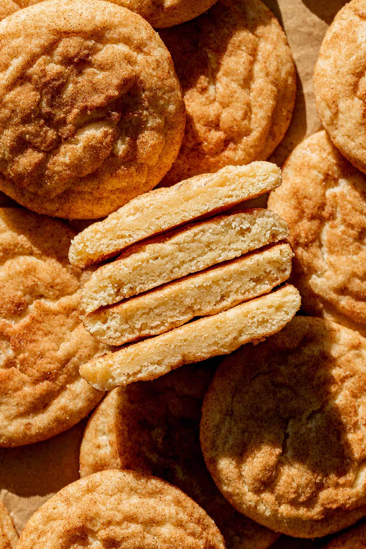 thick and soft snickerdoodles cut in half and lined up to show inside texture.