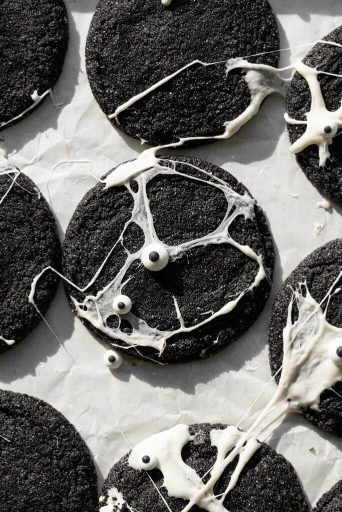 baked Spiderweb Black Velvet Cheesecake Cookies on parchment paper.
